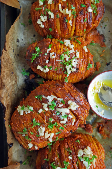 Indian Tandoori Hasselback Potatoes topped with Garlic and Coriander Butter on parchment paper