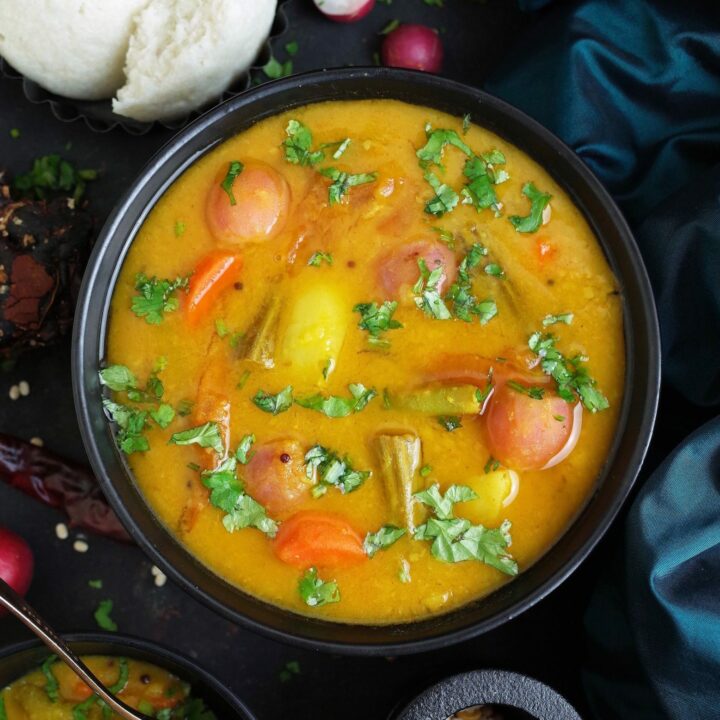 South Indian Vegetable Sambar in a black bowl with Idli