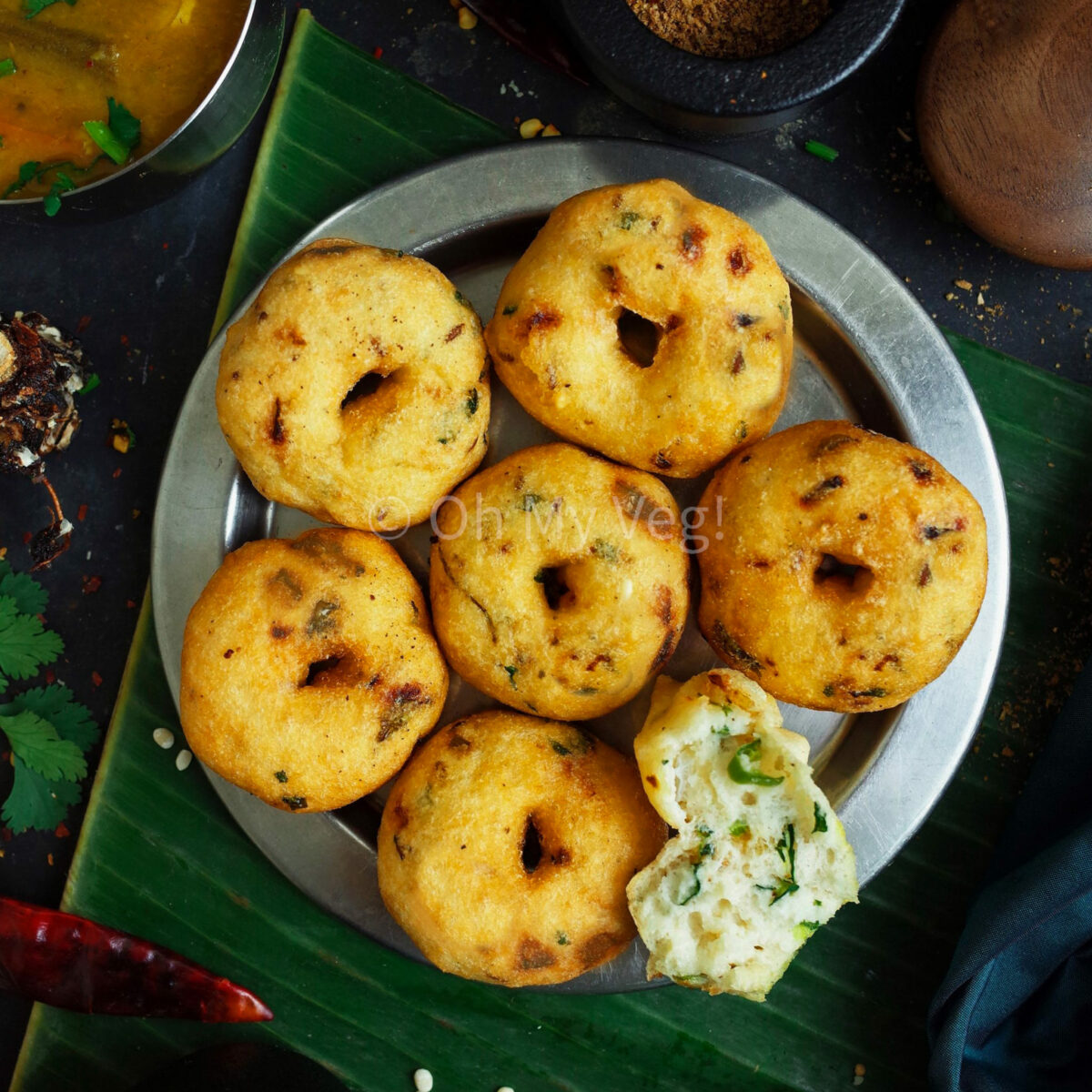 Medu Vada on a steel plate with banana leaf in the background