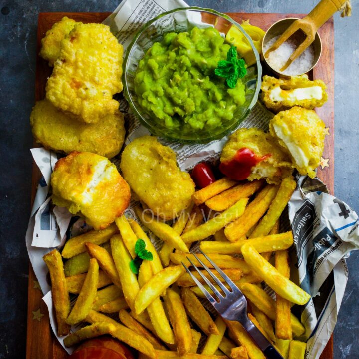 A tray with homemade chips, halloumi fish, mushy peas and ketchup