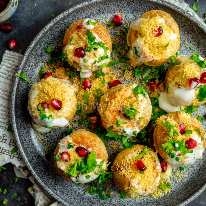 Indian dahi puri on a plate, topped with sev and pomegranate