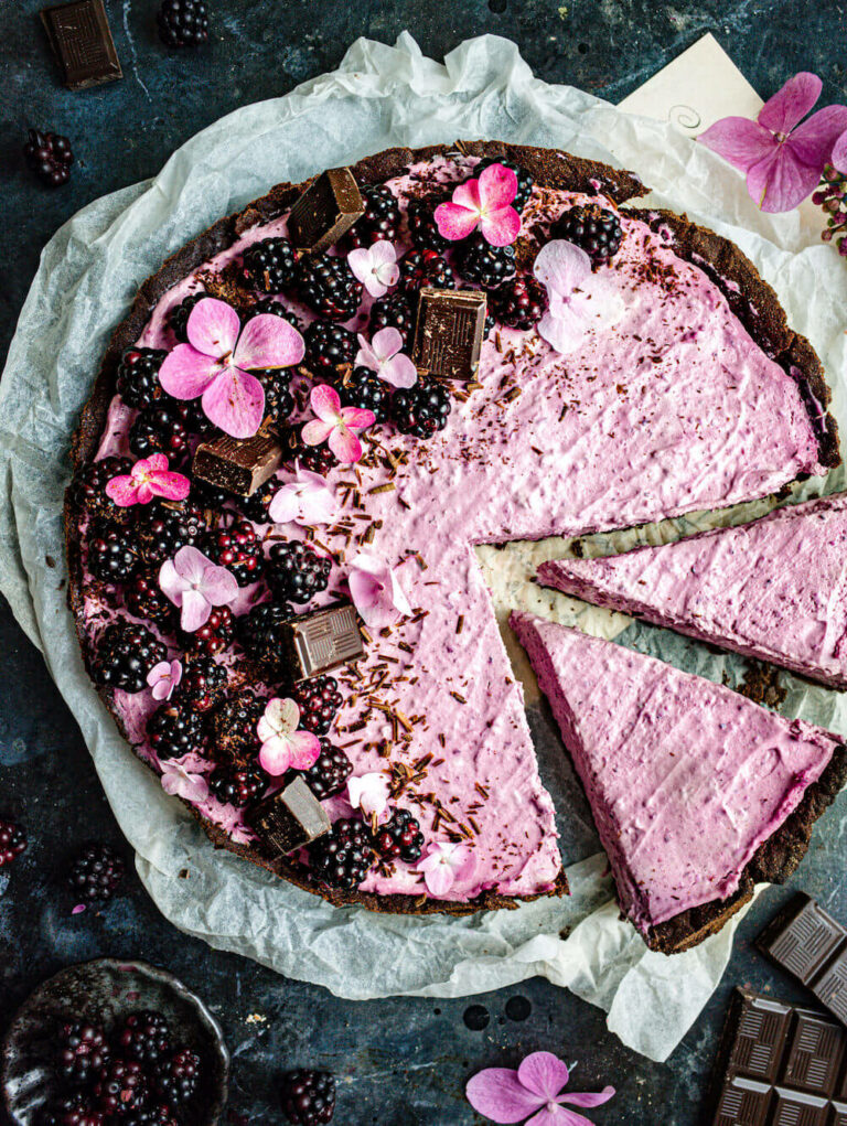 Blackberry and chocolate mascarpone tart with two slices cut out.
