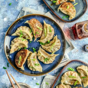 Vegetable gyoza on blue plates.