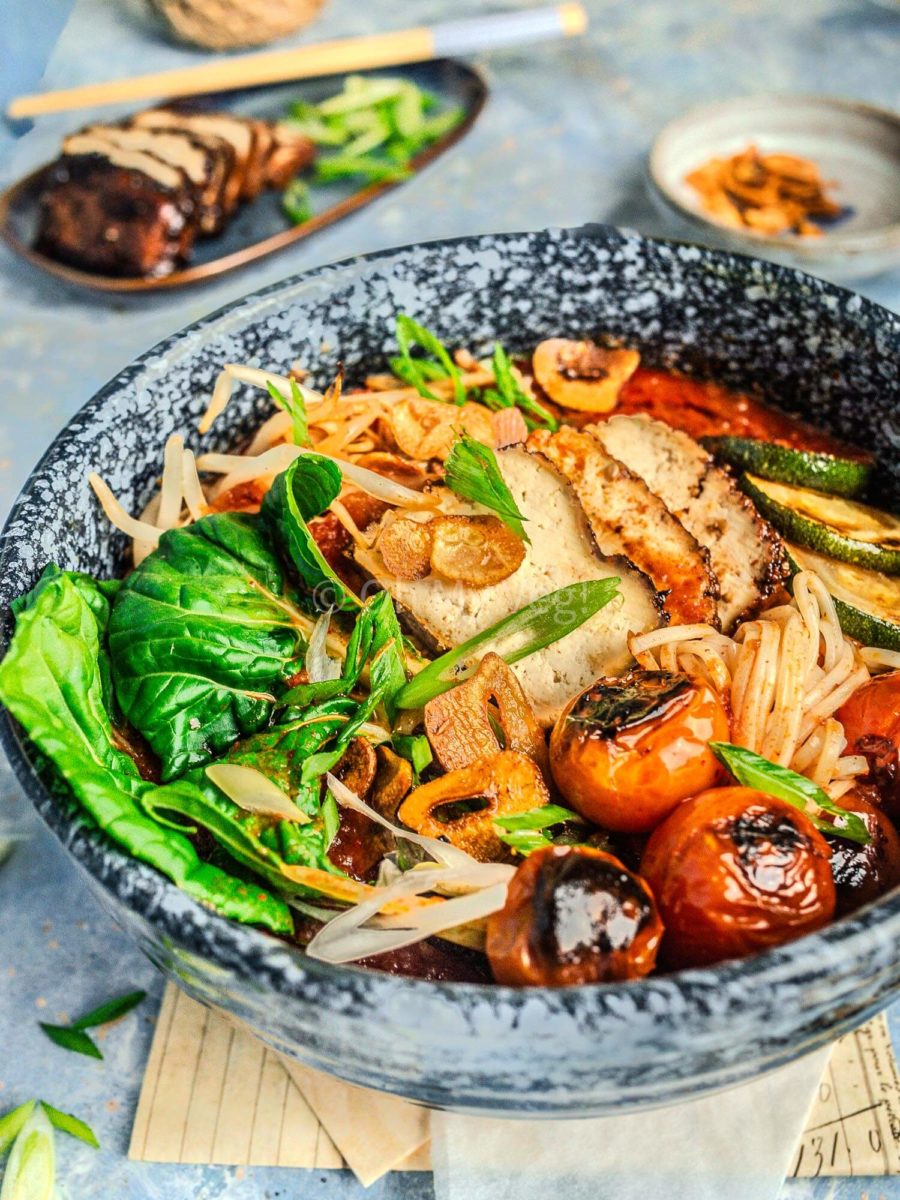 Vegan spicy tomato ramen with bok choy, charred tomatoes, and tofu topping.