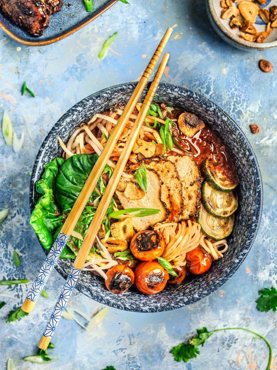 Spicy tomato ramen in a blue bowl with chopsticks.