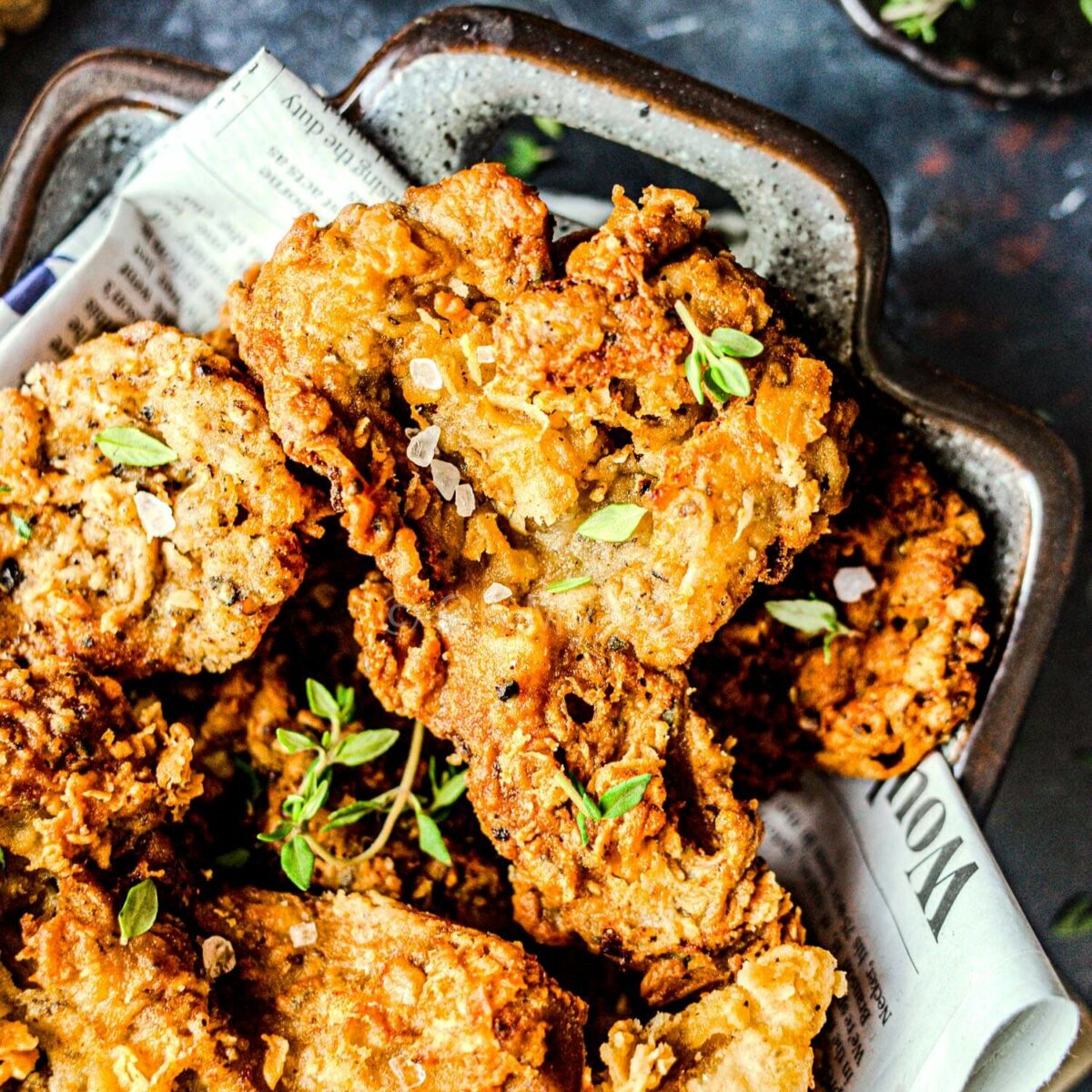 Crispy vegan fried chicken pieces topped with thyme.