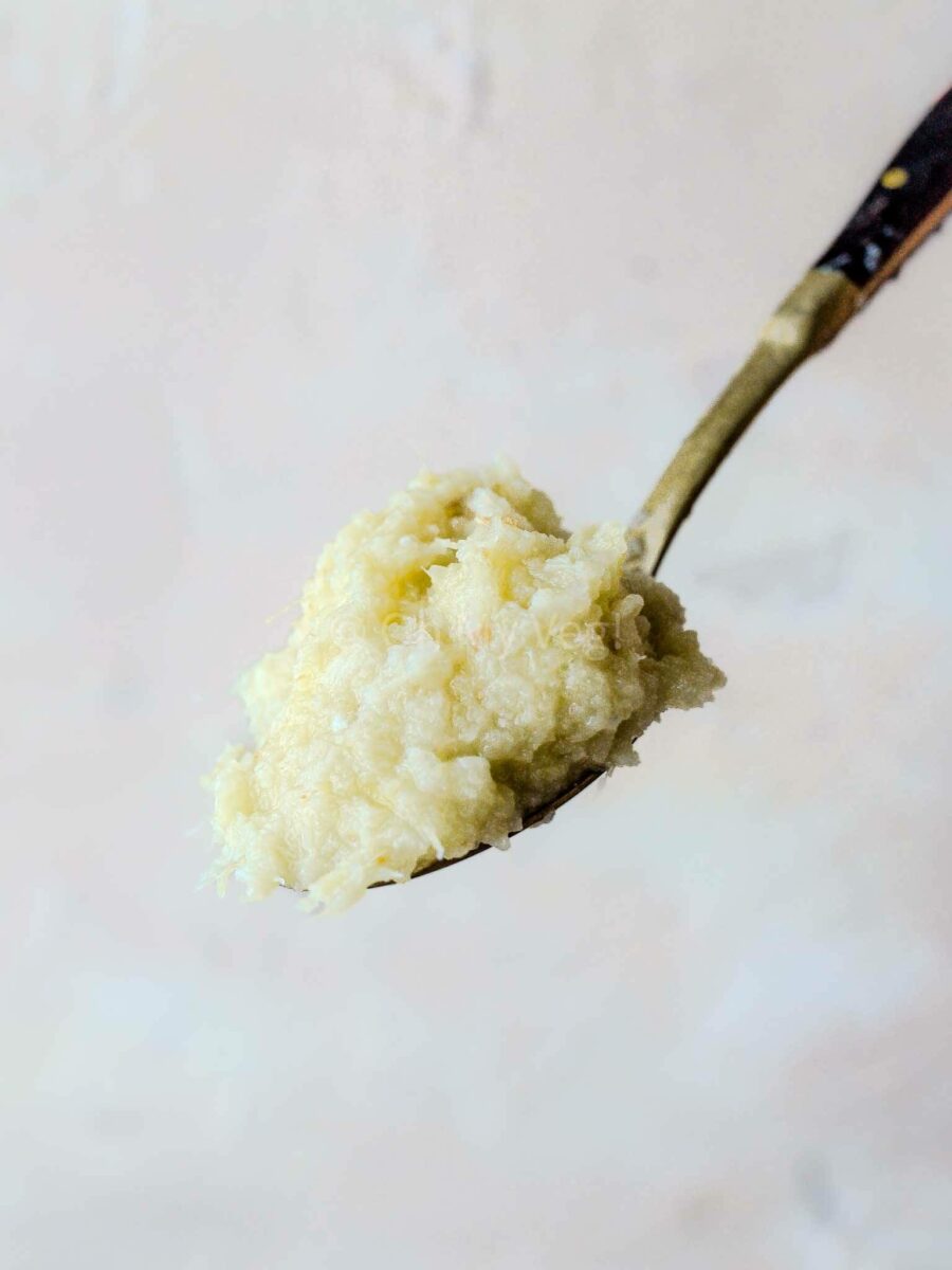 Homemade ginger garlic paste on a spoon.