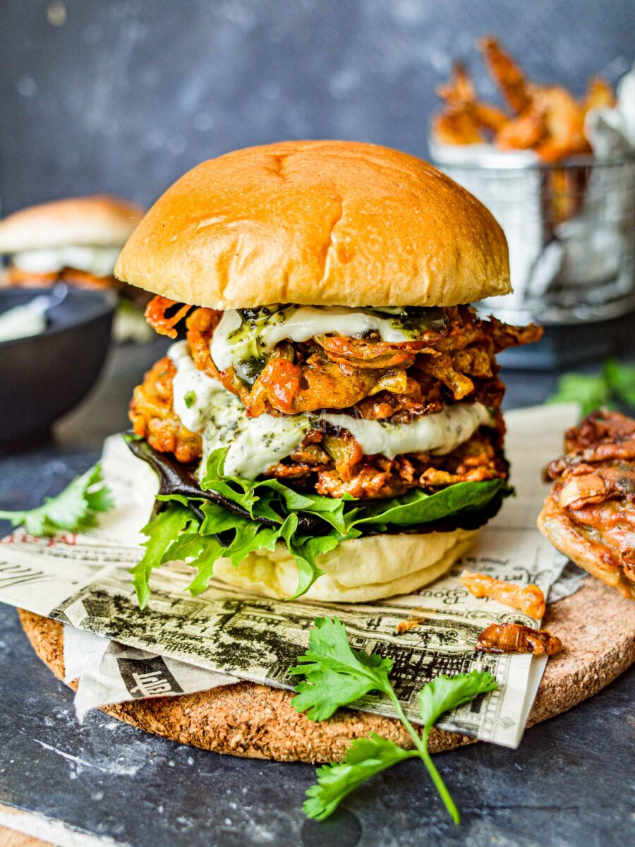 Onion bhaji burger on newspaper.