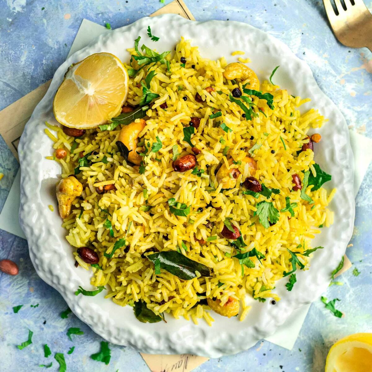 Chitranna or South Indian lemon rice, on a plate with fresh herbs.