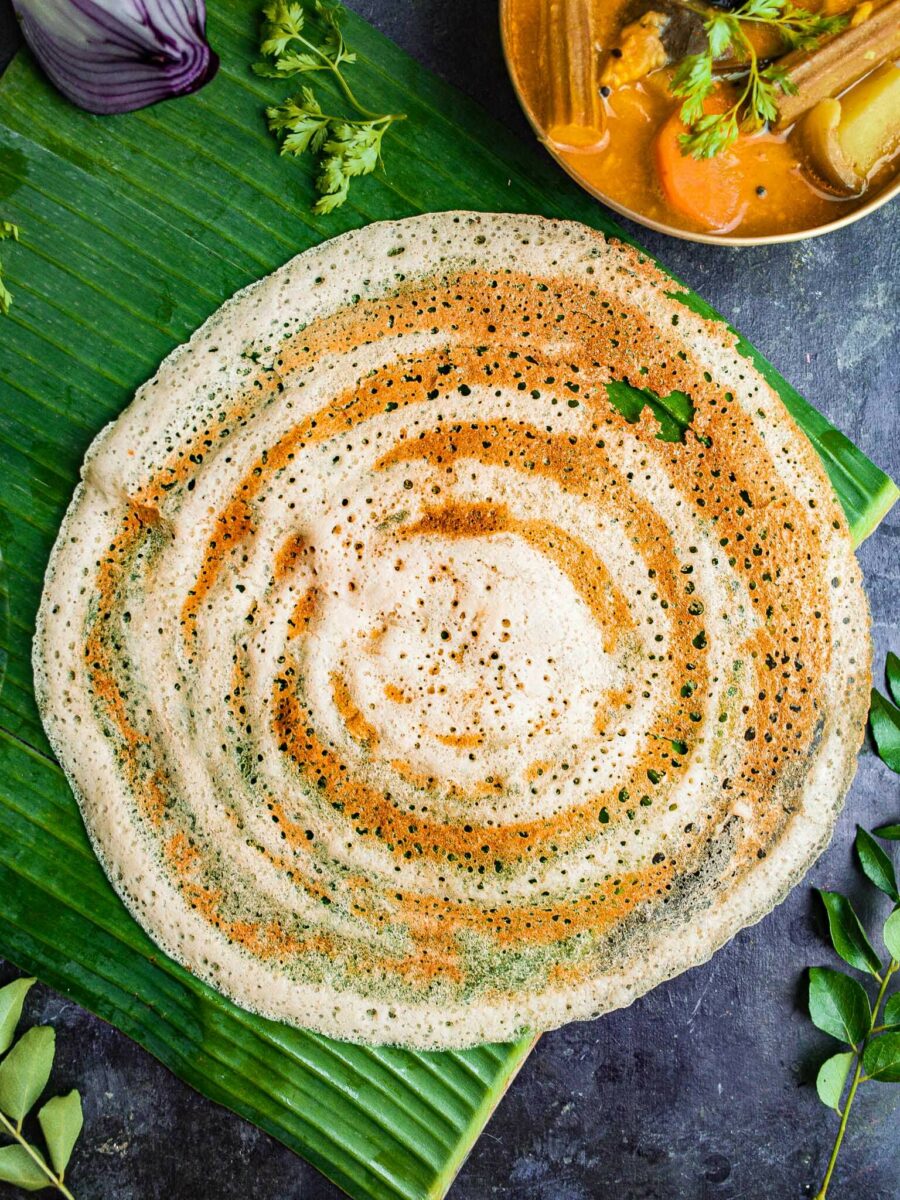 Gluten free dosa without any fillings on a banana leaf.