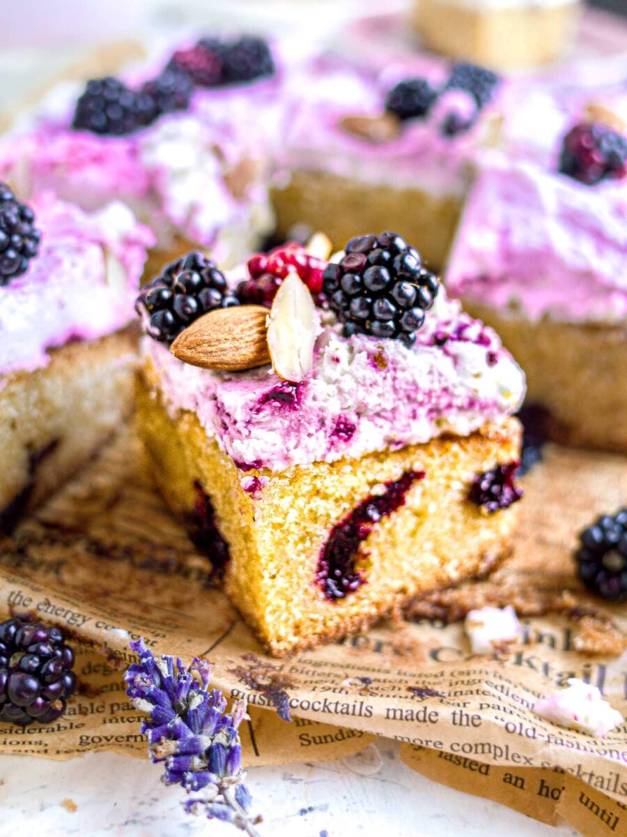 Blackberry almond cake on brown printed parchment paper. 