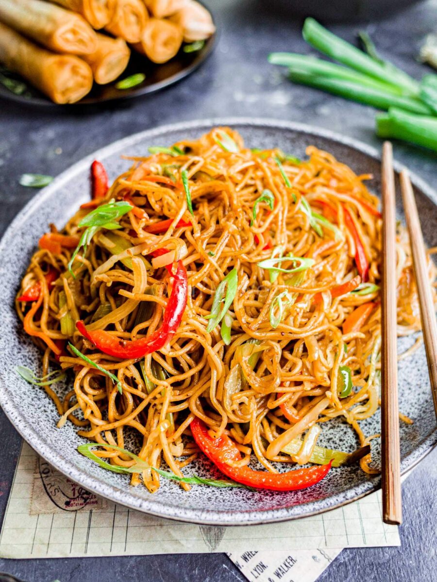 Veg hakka noodles on a grey plate.