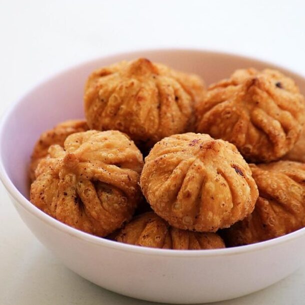 Fried modak in a white bowl.