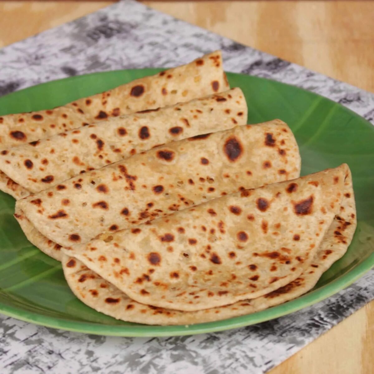 Puran poli on a banana leaf plate.