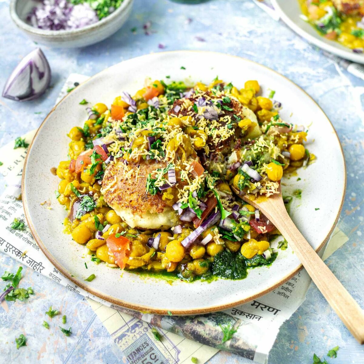 Ragda Patties on a white bowl with a small wooden spoon.