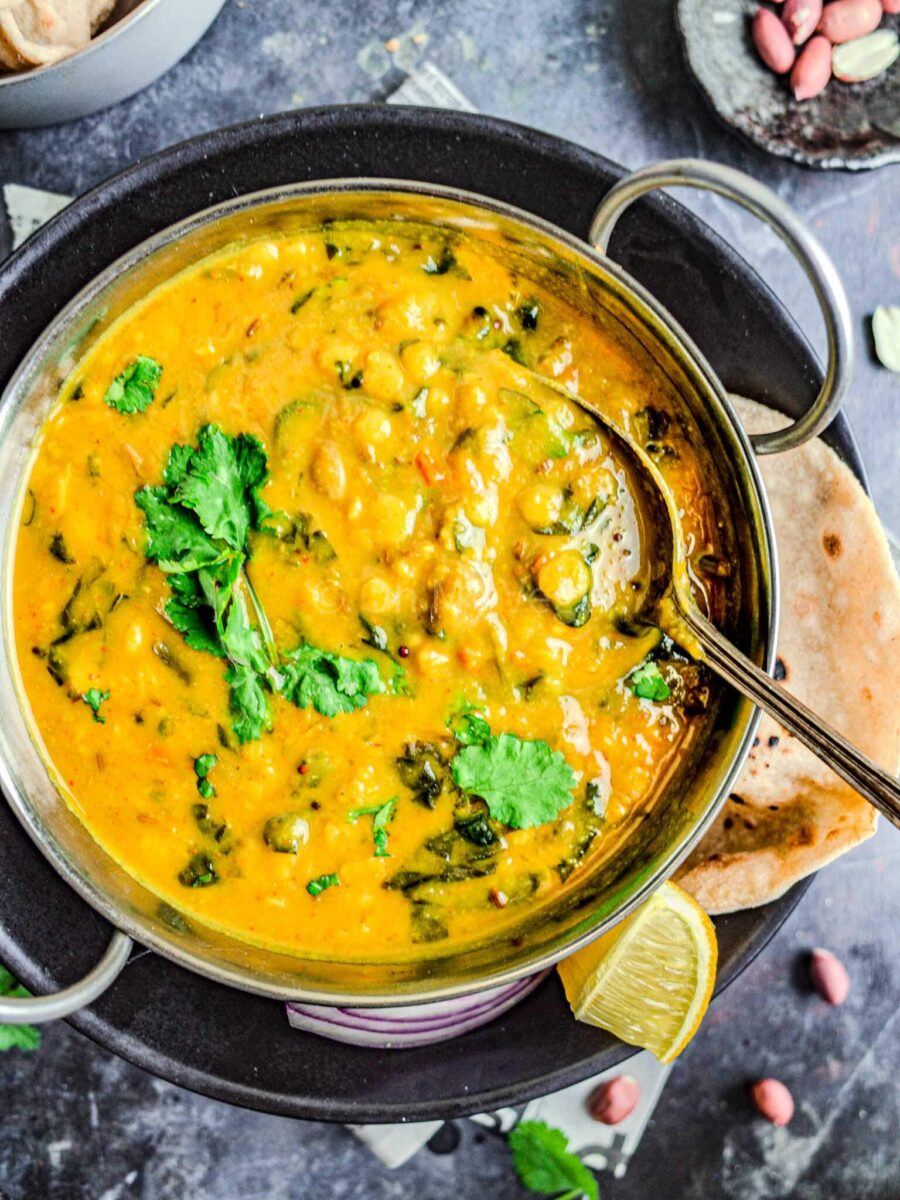 Dal bhaji in a kadai with a metal spoon.