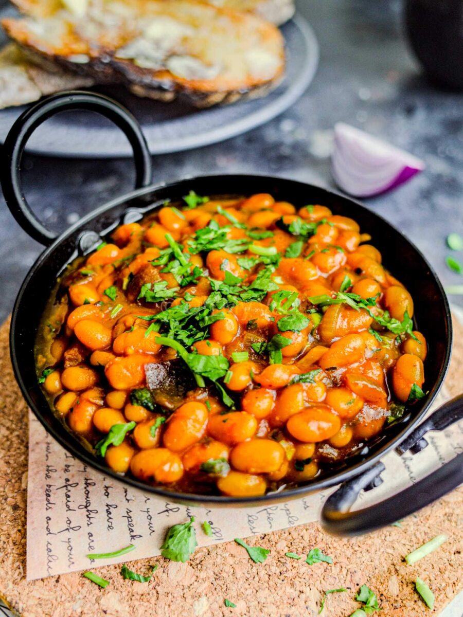 Masala beans in a black kadai. 