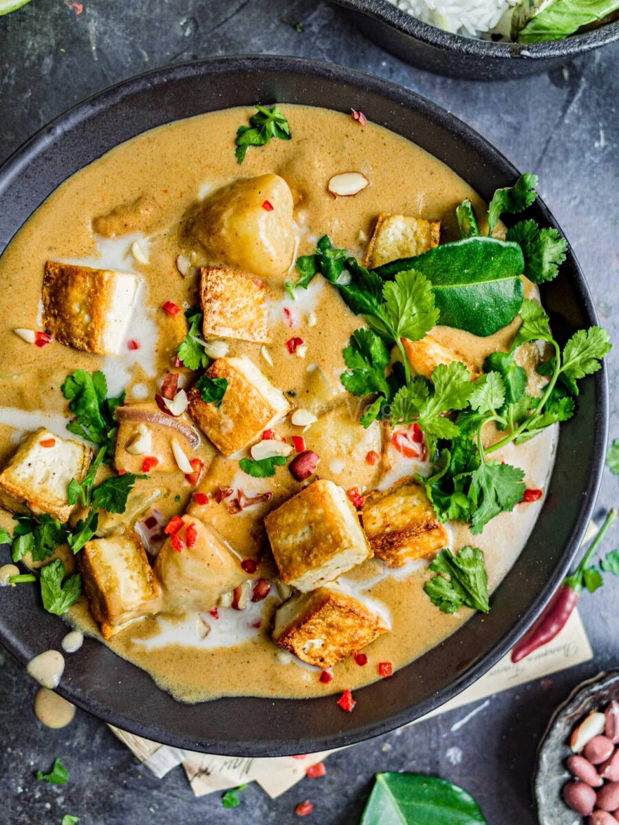 Tofu massaman curry in a black bowl.