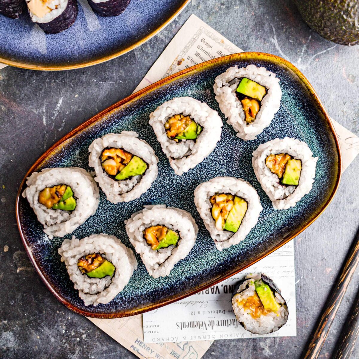 Peanut avocado rolls on a blue platter.