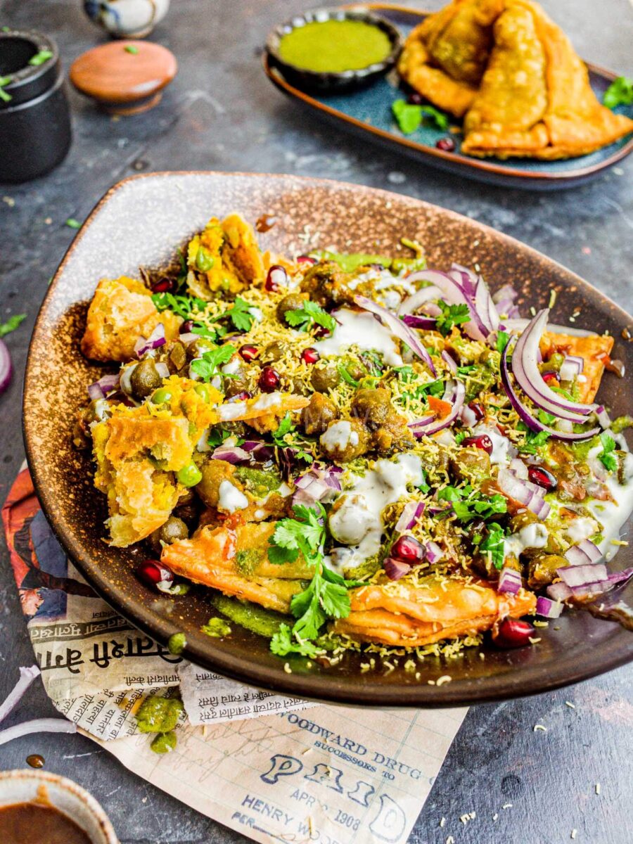 Samosa chaat in a bowl, with chutneys and garnishes. 