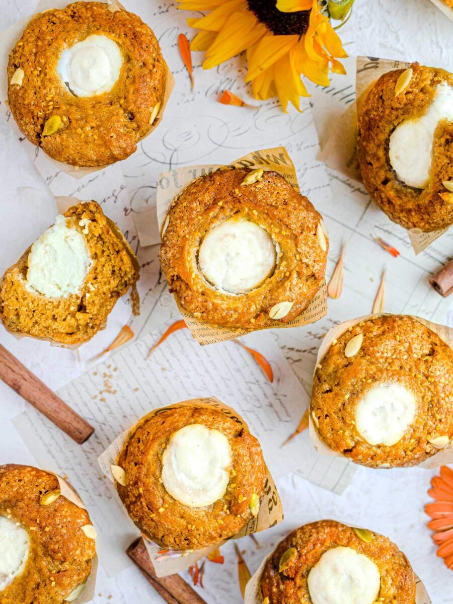 Eight pumpkin muffins above above, on white paper.