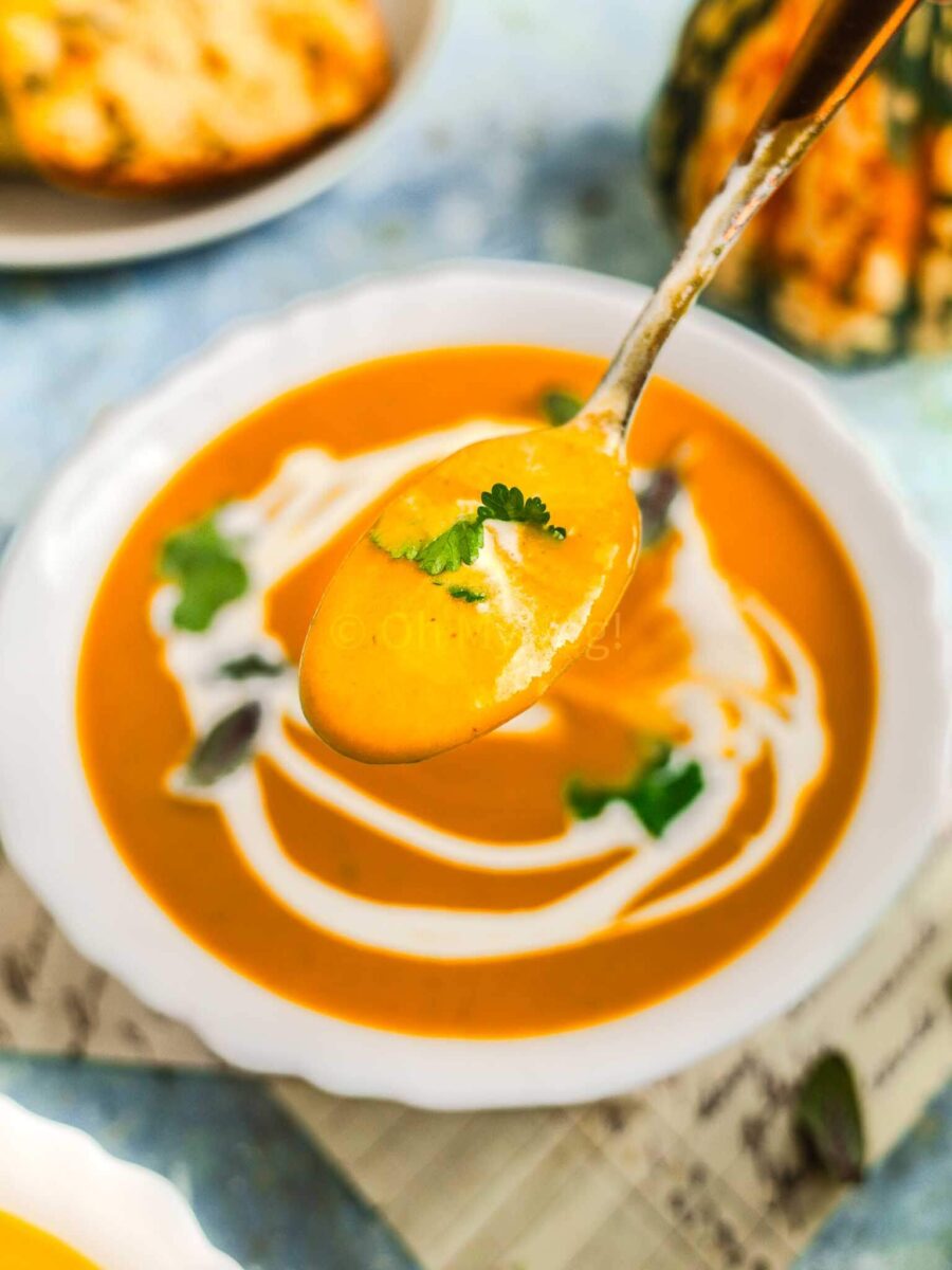 Pumpkin and sweet potato soup on a spoon.