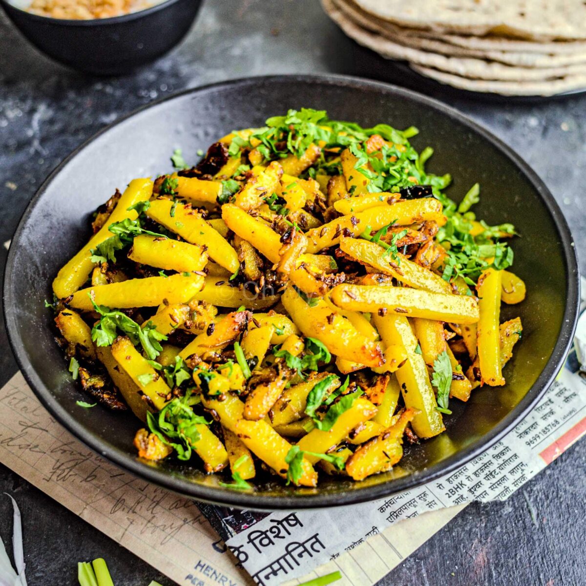 Aloo bhujia sabji in a black plate.