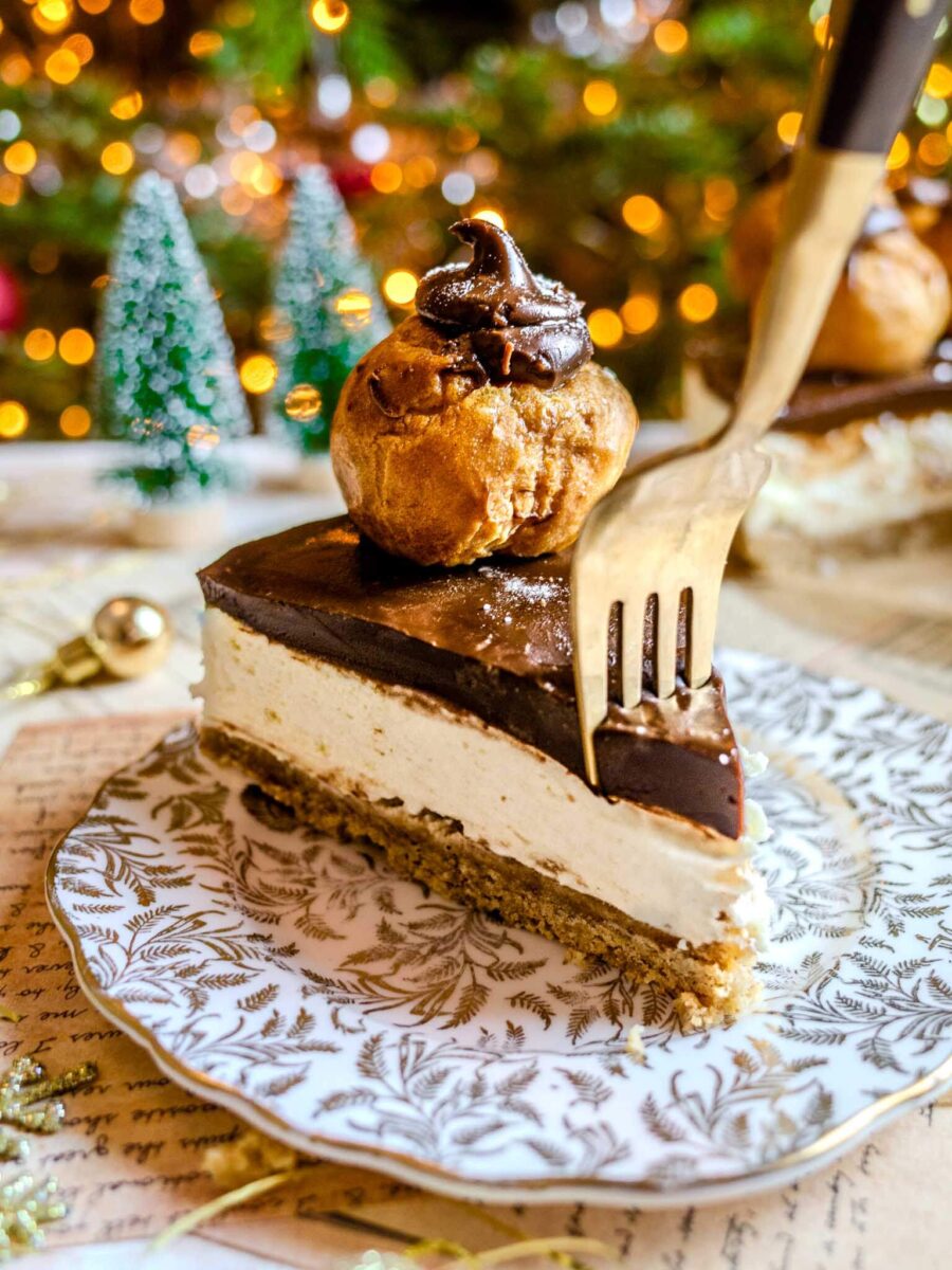 Fork cutting into a slice of profiterole cheesecake. 