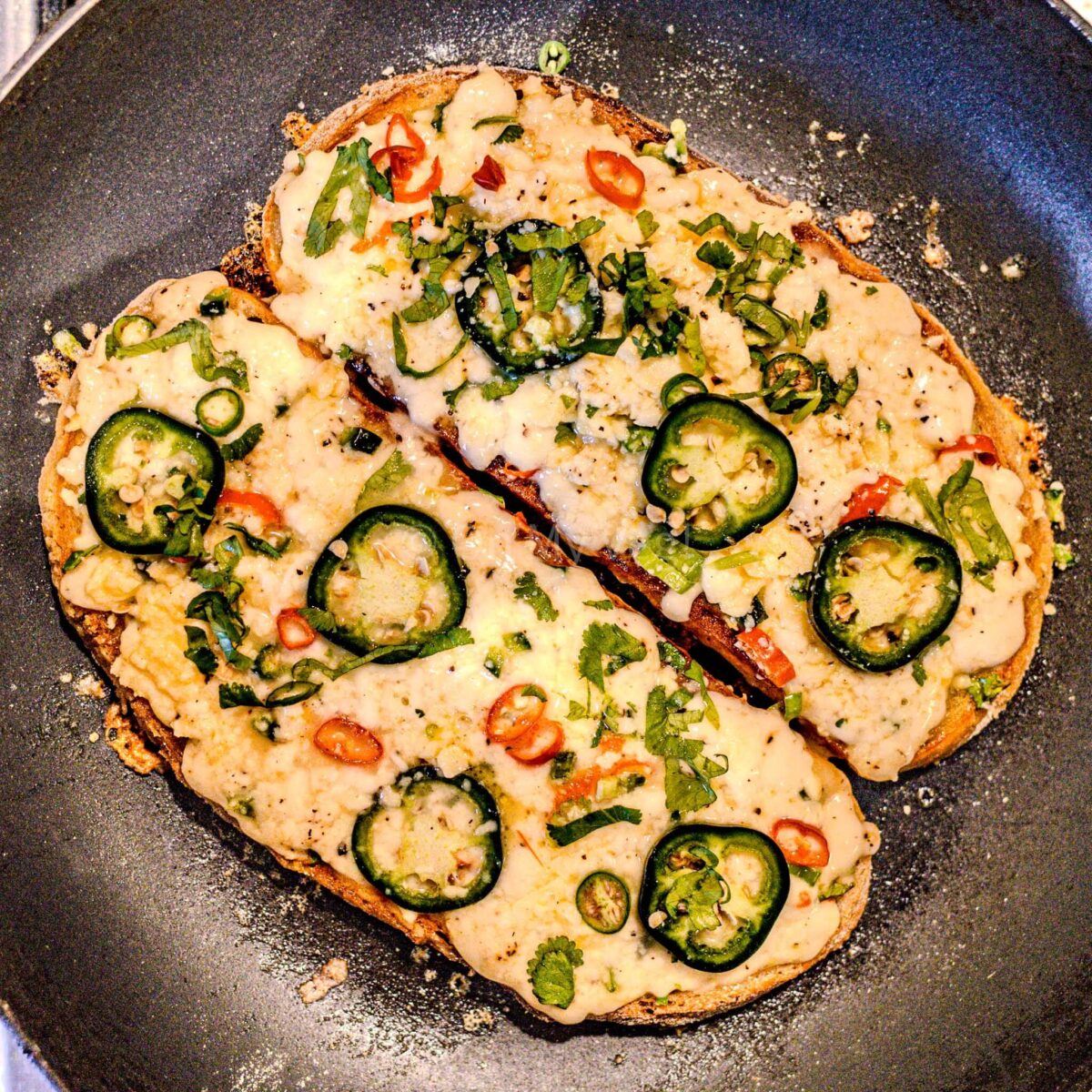 Chilli cheese toast with melted cheese in a pan.