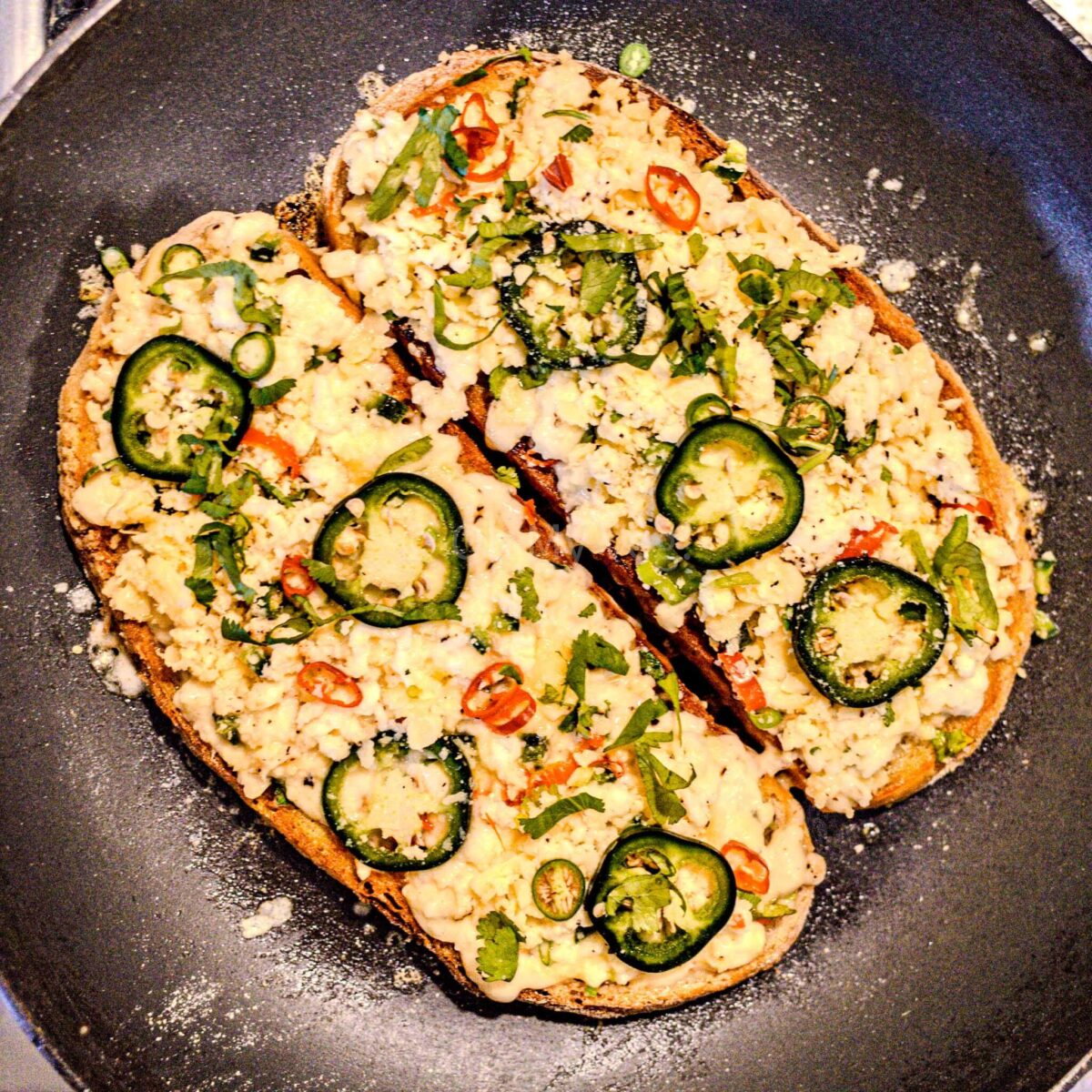 Chilli cheese toast cooking in a pan.