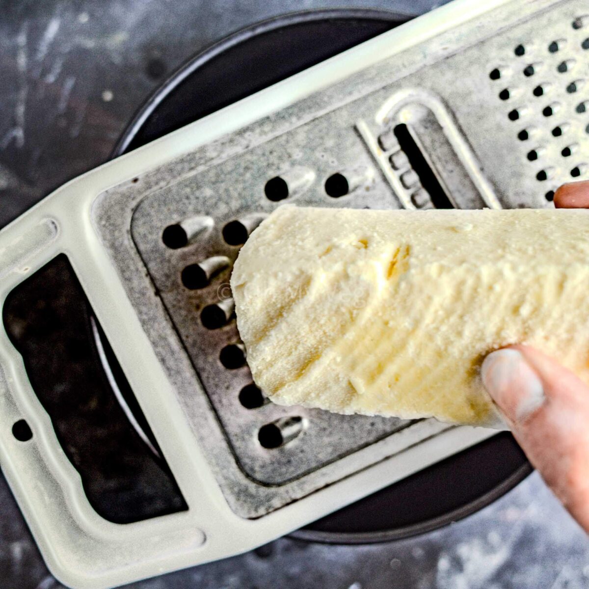 Cheddar cheese being grated.