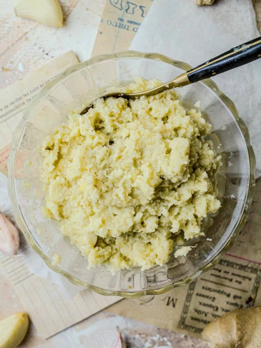 Indian ginger garlic paste in a glass bowl, with a spoon.