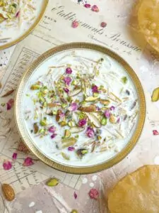 Seviyan kheer in a white bowl with puris.