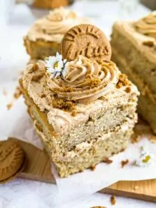 Banana and Biscoff cake slice with icing and Lotus Biscoff biscuit on top.