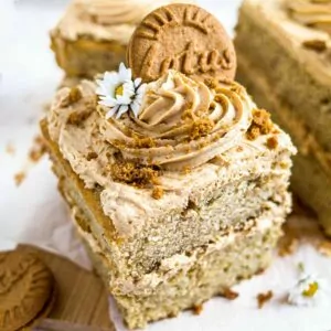 Banana and Biscoff cake slice with icing and Lotus Biscoff biscuit on top.